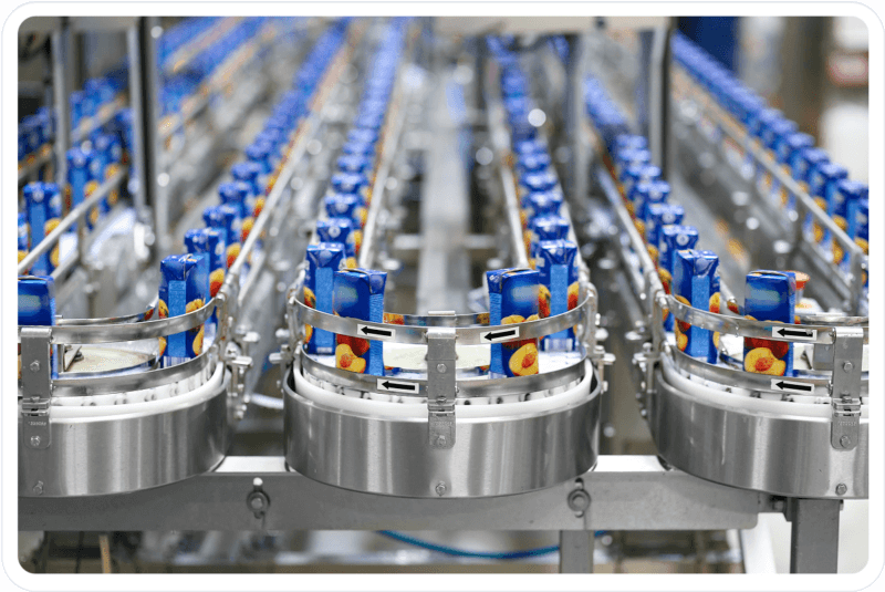 Automated conveyor system moving packaged fruit juice cartons in a food and beverage manufacturing facility